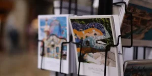 Close-up of a postcard stand in Barcelona, featuring vibrant images of Park Güell and iconic city landmarks.