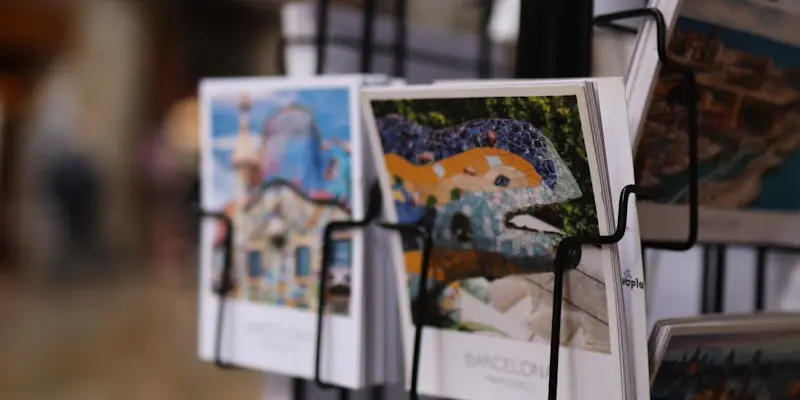 Close-up of a postcard stand in Barcelona, featuring vibrant images of Park Güell and iconic city landmarks.